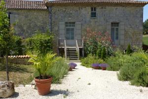 a garden in front of a stone house at La Mouline de Belin in Lectoure