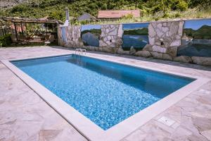 a swimming pool in a yard with a stone wall at Gazdinstvo Vukanović - Kuća za odmor in Trebinje +43 photos