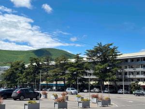 a parking lot with a building and a mountain at Elan apartment in Gori