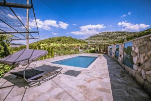 a house with a swimming pool and a chair at Gazdinstvo Vukanović - Kuća za odmor in Trebinje
