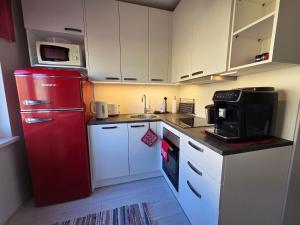a kitchen with a red refrigerator and white cabinets at Apartment Südalinnas in Haapsalu