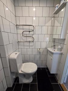 a white bathroom with a toilet and a sink at Apartment Südalinnas in Haapsalu +9 photos