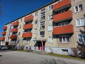 an apartment building with red balconies on a street at Apartment Südalinnas in Haapsalu