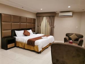 a bedroom with a large bed and a chair at ashbona suites in Riyadh +29 photos