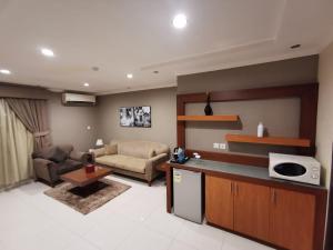 a kitchen and living room with a couch and a table at ashbona suites in Riyadh