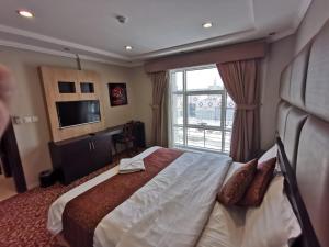 a hotel room with a large bed and a window at ashbona suites in Riyadh