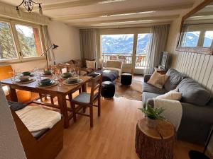 a living room with a table and a couch at 3BR Central Pool Sauna Gym & Views in Verbier