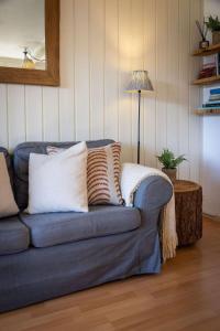 a blue couch with pillows in a living room at 3BR Central Pool Sauna Gym & Views in Verbier