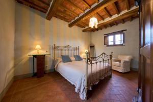 a bedroom with a bed and a chair and a window at Conca d'Oro casale con piscina privata in Foiano della Chiana +50 photos
