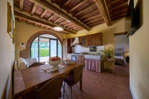 a kitchen with a table with a bowl of fruit on it at Conca d'Oro casale con piscina privata in Foiano della Chiana