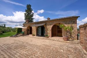 a brick building with a patio in a yard at Conca d'Oro casale con piscina privata in Foiano della Chiana
