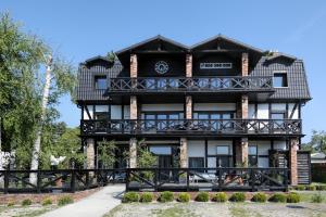 a large black and white building with a balcony at DOM NAD MORZEM PoDDĄBIE, TARAS WIDOKOWY ZE STREFĄ WYPOCZYNKU, SALA ZABAW in Poddąbie