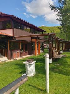 a building with a bench in the grass in front of it at Alpinlife in Dejani