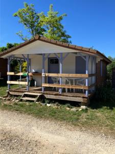 a small house with a porch and a table at Camping familial 3 Etoiles avec piscine Carrefour de l'Ardèche in Saint-Remèze +38 photos