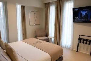 a hotel room with a bed and a flat screen tv at Centrale Hotel in Tirana