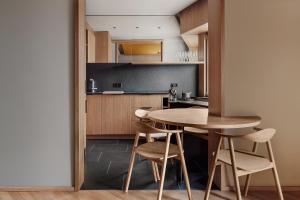 a kitchen with a table and chairs in a room at Woodline Suite in Luxembourg