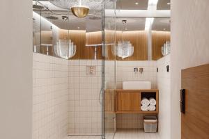 a bathroom with a shower with a glass door at Woodline Suite in Luxembourg