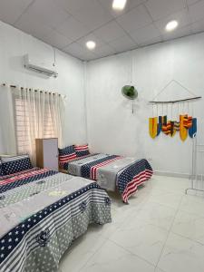 two beds in a room with american flags at Châu Gia Vỹ Dạ Hàn Mạc Tử in Thôn Lại Thê