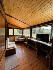 a room with a piano in a room with windows at Alpinlife in Dejani