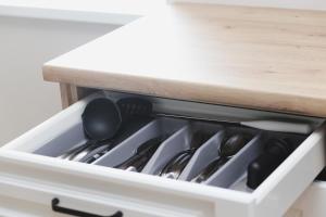 eine Schublade voller Küchenutensilien in einem Schrank in der Unterkunft Parko7 apartamentai in Plateliai + 18 Fotos