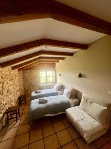 a bedroom with two beds and a couch at The Pilgrim Stone - Vegan B&B in Rabanal del Camino