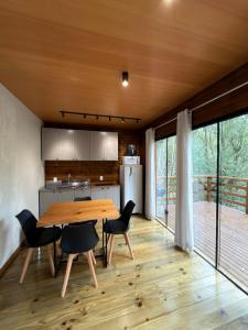 a kitchen and dining room with a wooden table and chairs at Cabana Penélope in Alfredo Wagner +33 photos