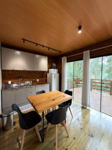 a kitchen with a wooden table and chairs at Cabana Penélope in Alfredo Wagner