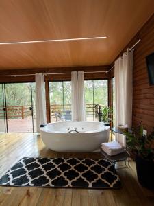 a large bath tub in a room with a large window at Cabana Penélope in Alfredo Wagner