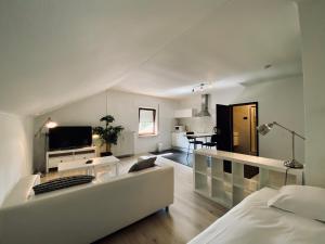a living room with a white couch and a tv at Hotel Pommerloch in Pommerloch