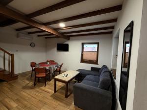 a living room with a blue couch and a table at Mazurskie El Dorado in Mikołajki