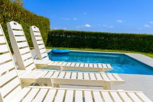 two white chairs sitting next to a swimming pool at Sumner Lake House 3B in Clermont