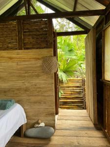 a bedroom with a bed in a wooden house at Ancestra black ecolodge in Nuquí