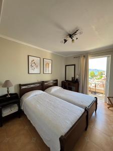 a bedroom with two beds and a window at Palatino in Loutra Edipsou
