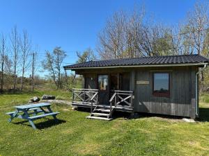a small cabin with a picnic table in the grass at Klobbars Gästhem o Stugor in Kökar