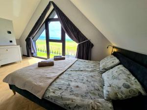 a bedroom with a large bed with a large window at Panorama Sudety in Nowa Bystrzyca