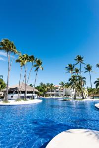 a swimming pool with palm trees on a beach at Occidental Punta Cana - All Inclusive in Punta Cana