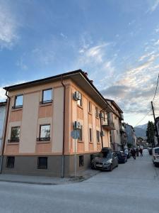 a building with cars parked in a parking lot at Legend Suites Bitola in Bitola