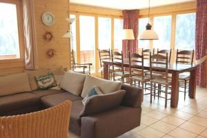 a living room with a couch and a table and chairs at Moilles 13 in Arni Alp