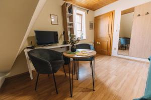 a living room with a table and chairs and a television at Apartman Susilova Slavkov in Slavkov u Brna