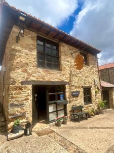 a stone building with a door and a window at The Pilgrim Stone - Vegan B&B in Rabanal del Camino