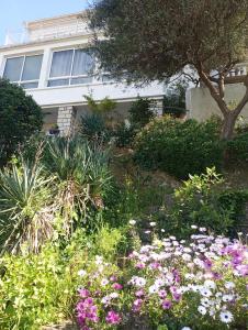 a garden with flowers in front of a building at Appartement Fort Lamalgue in Toulon