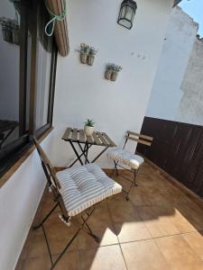 a balcony with two chairs and a table and a window at AT SAN PEDRO 2 in Olivenza