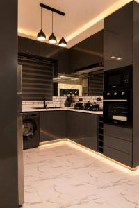 a kitchen with black cabinets and a washer and dryer at The COZY CREST in Akure