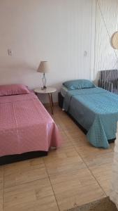 a bedroom with two beds and a table with a lamp at Moradas Jane in Paulo Lopes