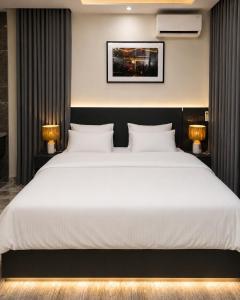 a bedroom with a large white bed with two lamps at The COZY CREST in Akure