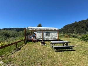 a yurt with a picnic table in a field at Emerald - Glamping tent in Klamath