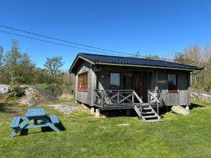 a small cabin with a blue picnic table in front of it at Klobbars Gästhem o Stugor in Kökar