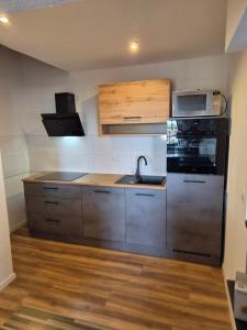 a kitchen with a sink and a microwave at Pottblick Oberhausen in Oberhausen +2 photos