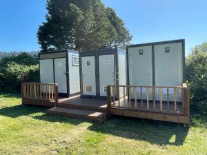 a couple of portable toilets sitting in the grass at Emerald - Glamping tent in Klamath +2 photos