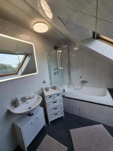 a bathroom with a sink and a bath tub and a sink at Pottblick Oberhausen in Oberhausen
